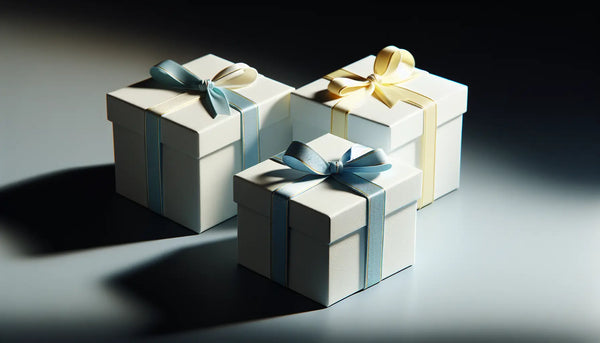 Elegante, schlanke Geschenkboxen mit blauem Band auf hellem Untergrund in warmem, einladendem Licht im Steelmonks Design.