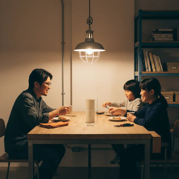 Intimes Abendessen mit Familie an Holztisch, warme Beleuchtung, metallische Details und dezente Markenakzente; alternativen zu jochen schweizer