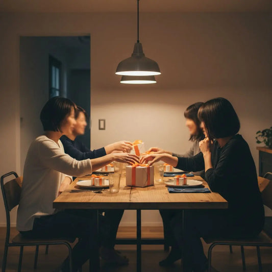 Gemütliches Esszimmer mit Holz­tisch und Händen, die nach kleinen Geschenkboxen greifen – geschenke zur goldenen hochzeit im Fokus, warmes Licht, leichter Industriecharme