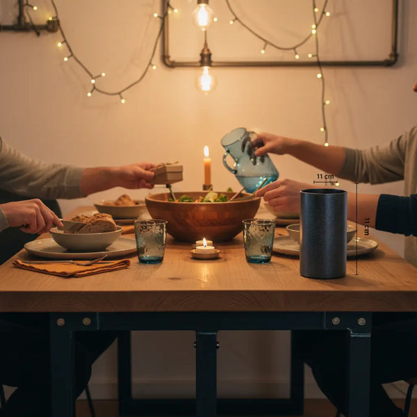 Freundinnen teilen einen Abend am Holz-Esstisch, Hände reichen ein Geschenk, warme Steelmonks-Ästhetik, geschenkideen für freundinnen, minimalistisch, warme Metall- und Holzdetails