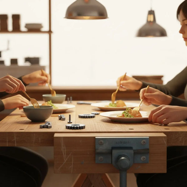 geschenkideen für papa: Nahaufnahme eines warmen Esszimmers mit Händen, die Teller und Werkzeuge teilen, minimalistisches, industrielles Holz‑ und Metalldesign