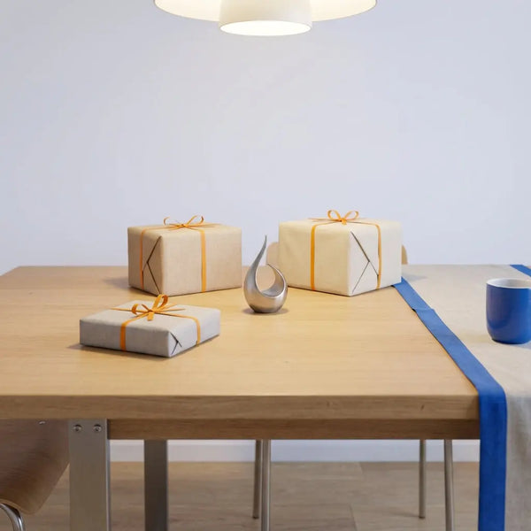 Minimalistisches Esstisch-Setup mit dezent verpackten Geschenken und eleganter Metalldekoration in warmem Licht, glückwünsche standesamtliche trauung