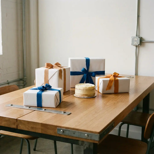Leerer Esstisch mit sorgfältig verpackten Geschenken und kleinem Vanillekuchen, warme Holztöne und Metallakzente, Hochzeitsgeschenk Zeitpunkt, minimalistisches Ambiente