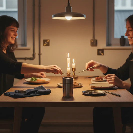 Gemütliche Abendtischszene mit Händen, Holz- und Metalldetails, Produkt aus den Referenzfotos im Vordergrund, warmes Licht, minimalistischer Stil, nikolausgeschenke