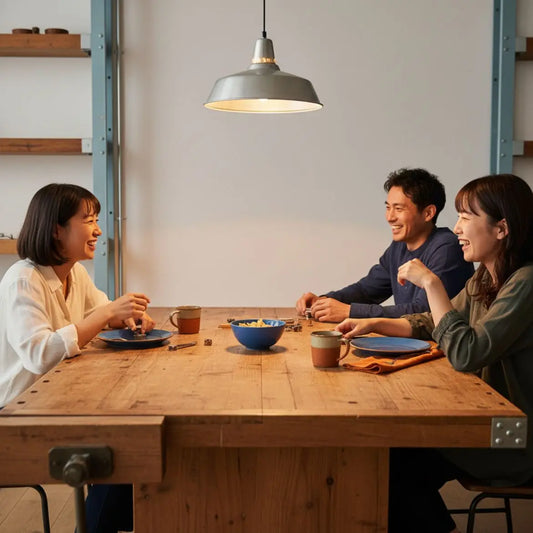 Kleine Familie teilt warmes Abendessen im hellen, leicht industriellen Esszimmer – romantische geschenke mann als Geschenkidee, Nähe und geteilte Gegenstände