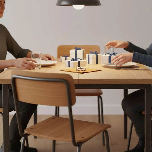 Gedeckter Esstisch mit kleinen tröstgeschenke, Händen beim Eindecken und dezenter Metallanhänger, warmer industrieller Charme mit Holzoberfläche und Metalldetails.