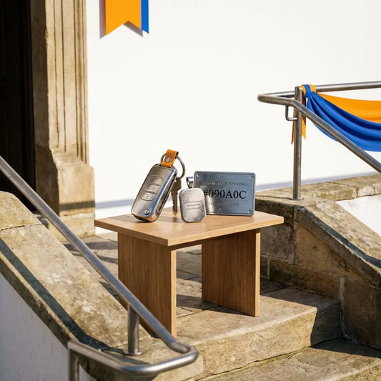Überraschung nach dem Standesamt: minimalistischer Tisch vor dem Rathaus mit robusten Metallgeschenken, warmes Tageslicht und dezente Steelmonks-Farben