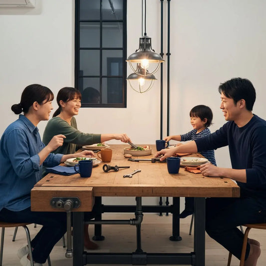 Freunde oder kleine Familie um Esstisch mit warmem Licht, industriellen Metalldetails und Holzoberflächen, gemeinsames Lachen und Zusammensein — überraschungsideen freund