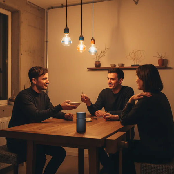 Familie teilt Abendessen an Holztisch mit metallischen Details und warmem Licht, intime Nähe und Lachen — was machen mutter gerne