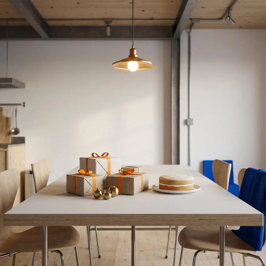 Wie viel Geld schenkt man zum 40. Hochzeitstag? Esstisch mit wenigen liebevoll verpackten Geschenken, simplen Vanillekuchen, warmes Licht und leichter Industriecharme mit Holz- und Metallakzenten