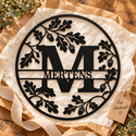 Schwarzes Eichenmonogramm mit M und MERTENS im Geschenkarrangement mit einem Anhänger „Zur Hochzeit“.
